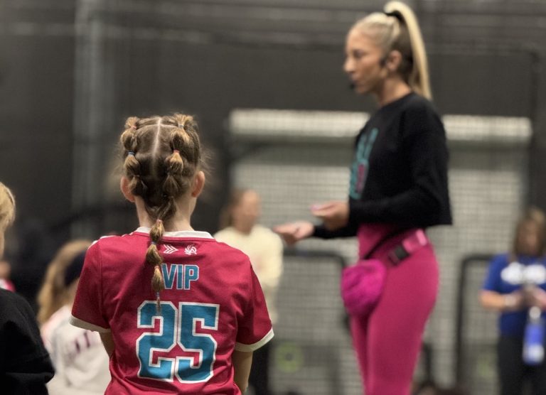 Amanda Scarborough provides instruction while a young camper listens intently
